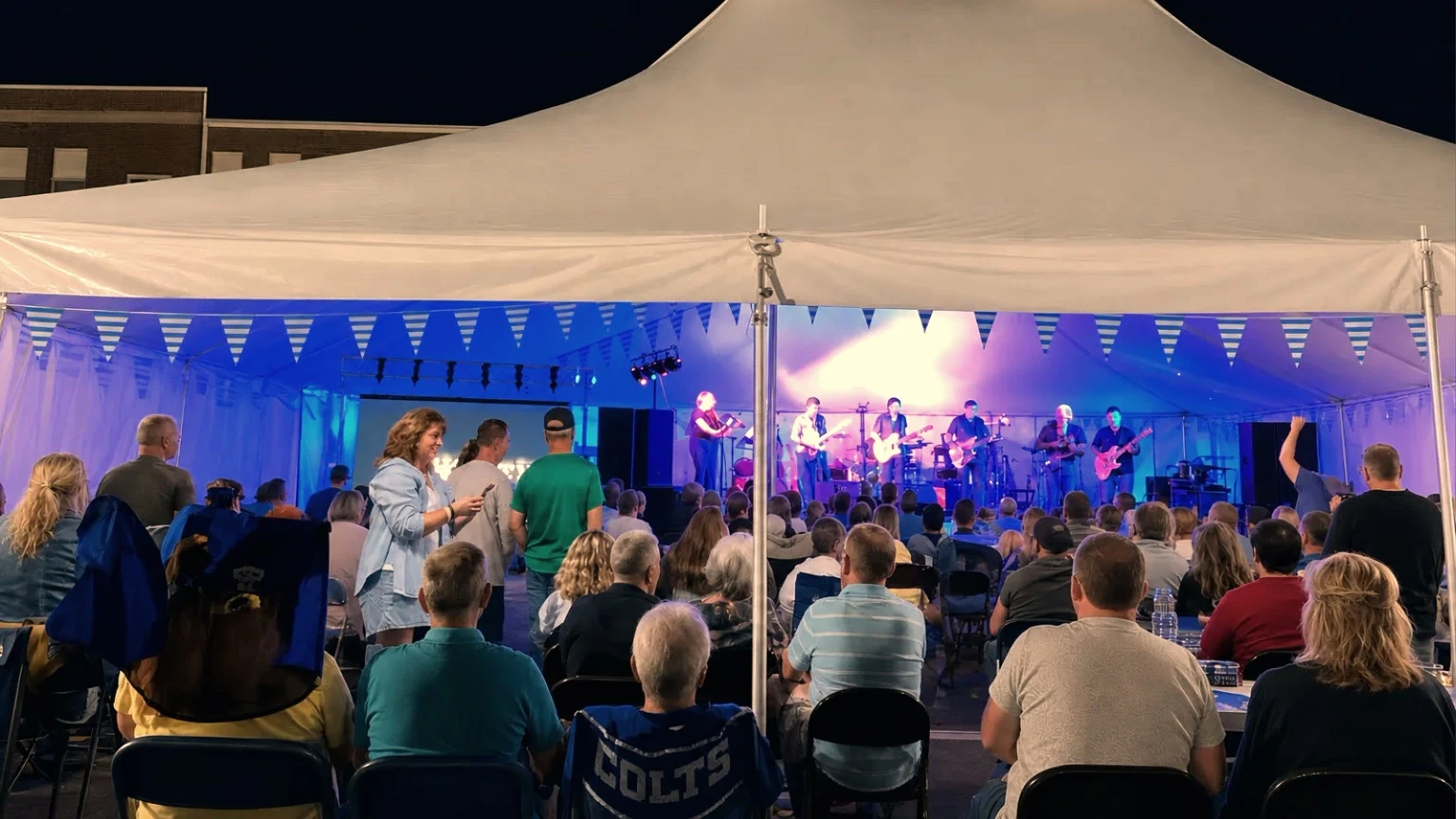 Band performing under festival tent at night